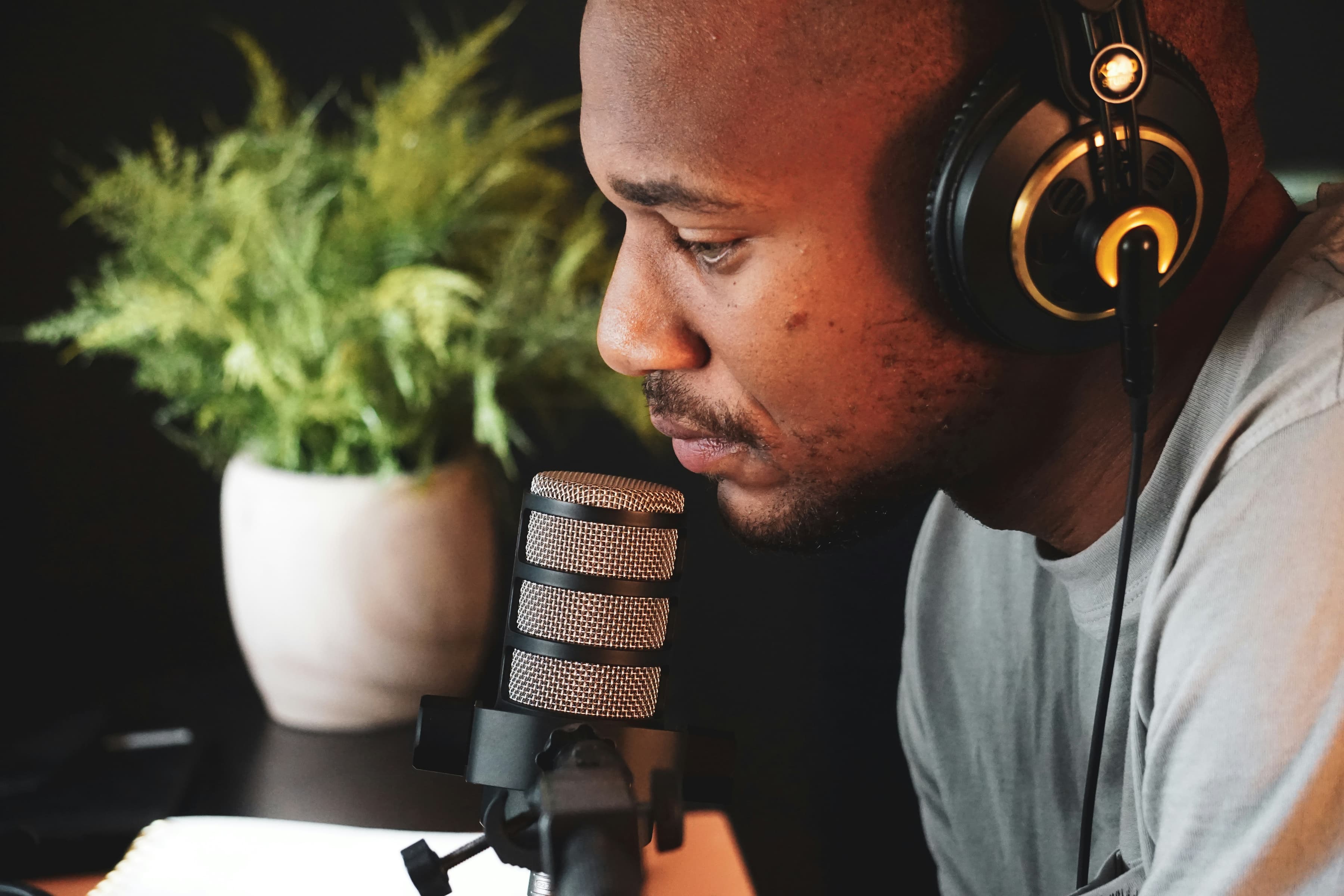 a man-wearing headphones is looking at a microphone